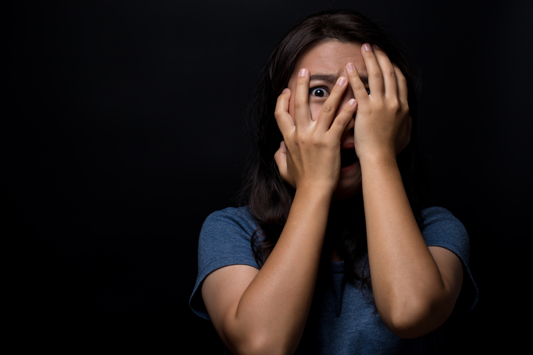 Scared woman on isolated black background